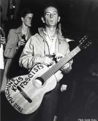 Woody Guthrie. På gitaren har han skrevet: This machine kills fascists