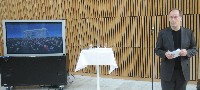 Tom Remlov foran det han mener vil bli Bjørvikas ikon-bilde, folkemassene som fulgte operapremieren på skjerm